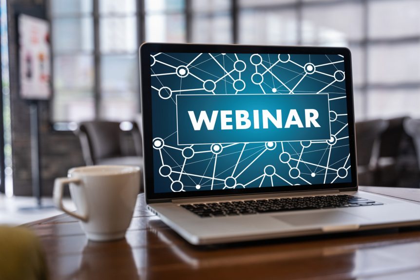 A webinar is shown on the laptop screen