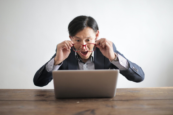 A man is surprised to see his laptop screen