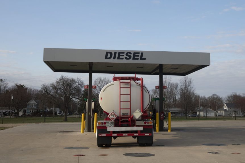 An oil tanker is standing in front of a diesel station