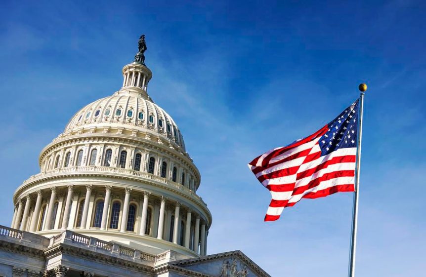 The national flag of USA is flying in front of The USA capitol